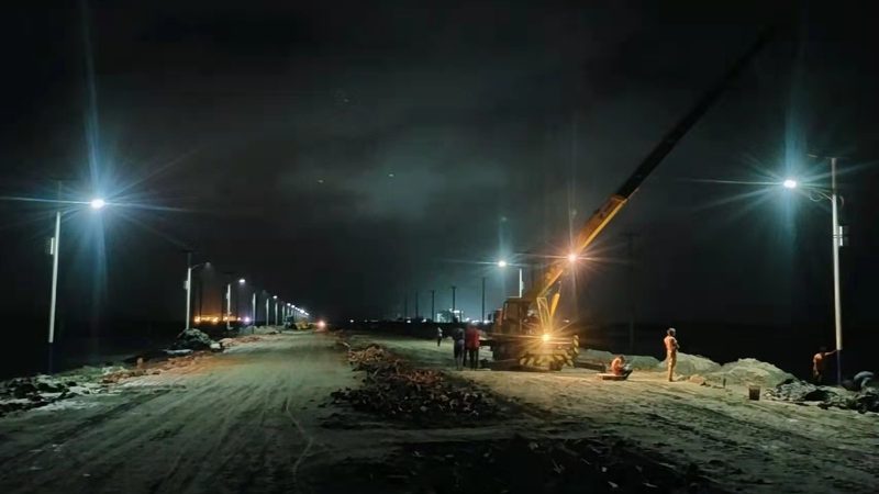 Solar street lights illuminating an industrial access road at night