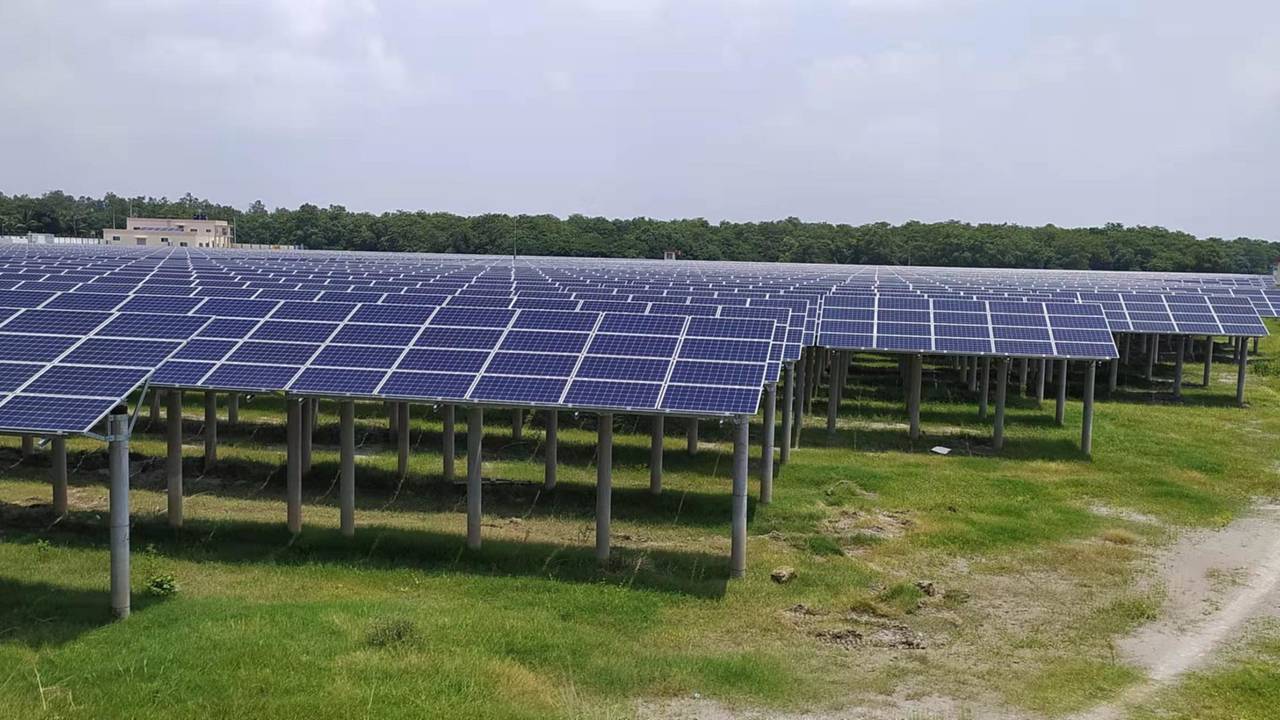 Rows of ground-mounted solar modules on steel structures at a grid-connected solar power plant