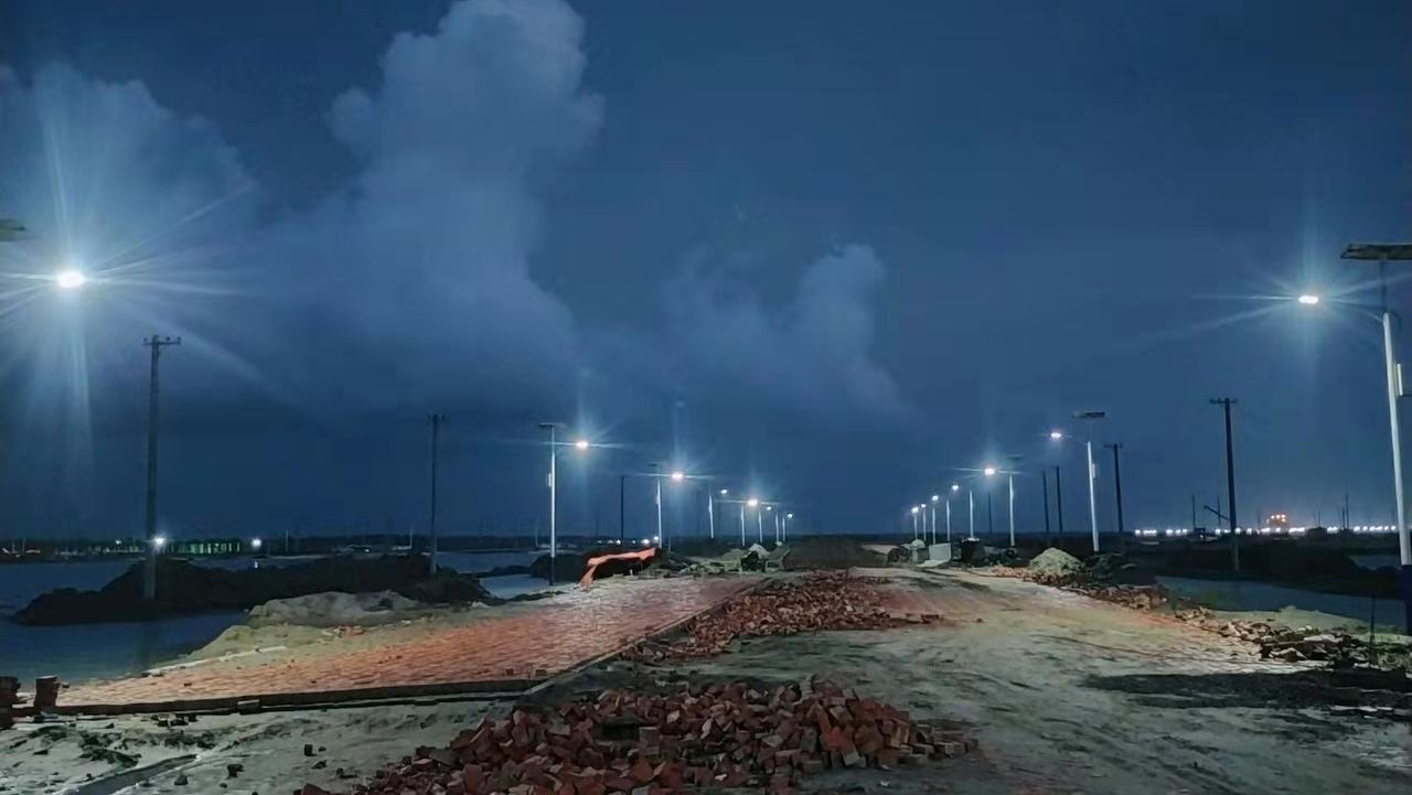 Solar street lights illuminating a road at dusk in an industrial economic zone