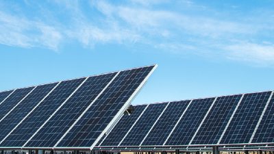 Rows of ground-mounted solar modules on fixed-tilt steel mounting structures